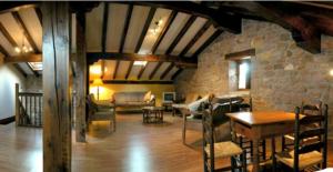 a living room with a couch and a table and chairs at Casa rural Ballenea in Errazu