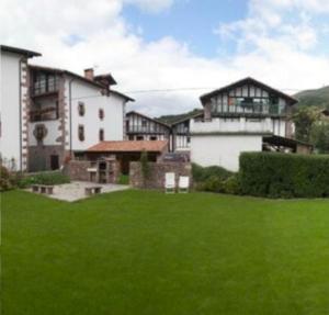 a large house with a green lawn in front of it at Casa rural Ballenea in Errazu