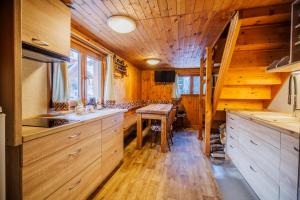 a kitchen with wooden cabinets and a wooden floor at Chata U Valentů in Červená Voda