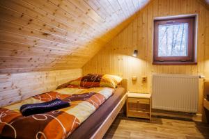 a room with a bed in a wooden house at Chata U Valentů in Červená Voda