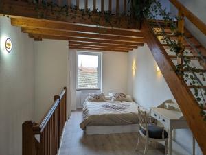 a bedroom with a bed and a desk and stairs at Cozy AM Spa and Cinema in Andance