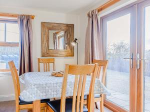 a dining room with a table and chairs and a window at The Barn in Kilmory