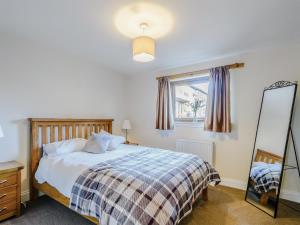 a bedroom with a bed and a mirror and a window at The Barn in Kilmory