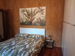 a bedroom with a bed and two paintings on the wall at Gerry Home in Valmadrera