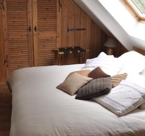 a bedroom with a bed with white sheets and pillows at L'herbe des nuits... in Pleyben