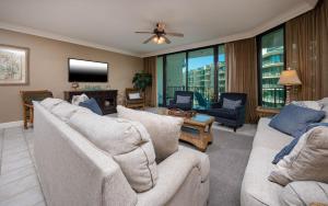 a living room with couches and a flat screen tv at Phoenix on the Bay 1324 in Orange Beach