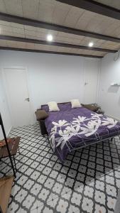 a bedroom with a bed with a purple comforter at Estudio en Blanes in Blanes
