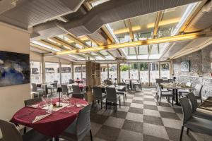 un ristorante con tavoli, sedie e finestre di Hôtel Terminus a Porrentruy