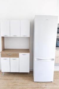 a white refrigerator in a kitchen with white cabinets at Appartement 5 pers proche plage Capesterre in Capesterre-Belle-Eau