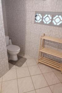 a bathroom with a toilet and a tiled floor at Appartement 5 pers proche plage Capesterre in Capesterre-Belle-Eau +6 photos