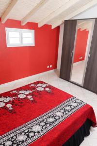a red room with a bed with a red wall at Appartement 5 pers proche plage Capesterre in Capesterre-Belle-Eau