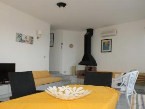 a living room with a yellow table and a couch at Belvilla by OYO Villa Eirene in Fontane Bianche