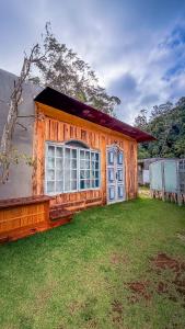 a house with a large window and a grass yard at Vila Carmen Imperial in Domingos Martins