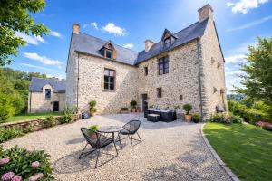 an exterior view of a large stone house with a table and chairs at Manoir de la coudre in Changé