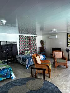 a living room with a bed and a couch at Eli Beach House in Vaiorea