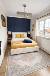 a bedroom with a large bed with a blue wall at Rossetti Retreat in Birchington