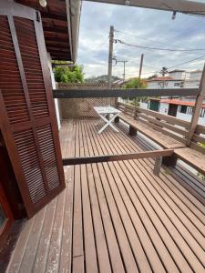 a wooden bench sitting on top of a deck at Quarto em casa próx a rua das pedras in Búzios