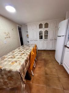 a kitchen with a bed in a room with a refrigerator at Quarto em casa próx a rua das pedras in Búzios +5 photos