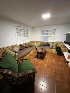 a living room with a couch and a table at Quarto em casa próx a rua das pedras in Búzios