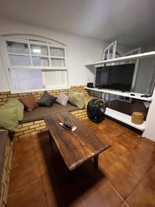 a living room with a couch and a table at Quarto em casa próx a rua das pedras in Búzios
