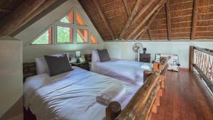 a bedroom with two twin beds in a attic at Inyathi Inn in Marloth Park +24 photos