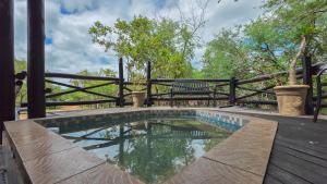 a small pool on a wooden deck with a bench at Inyathi Inn in Marloth Park