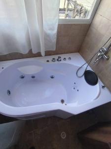 a white bath tub in a bathroom with a window at Puruha Inn in Riobamba +15 photos