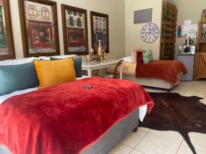 a bedroom with two beds and a clock on the wall at Magalies B&B SPITSKOP in Bloemfontein