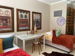 a bedroom with a desk and a bed and a clock at Magalies B&B SPITSKOP in Bloemfontein