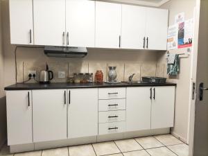 a kitchen with white cabinets and a counter top at Magalies B&B SPITSKOP in Bloemfontein