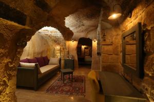 sala de estar con sofá en un edificio de piedra en Acropolis Cave Suite, en Ürgüp