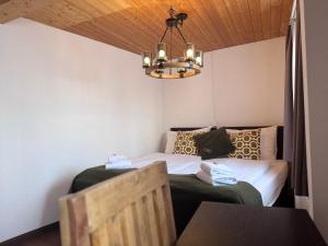 a bedroom with a bed and a chandelier at La Tgoma - Hotel & Restaurant in Lenz