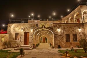 an old stone building with an archway at night at Acropolis Cave Suite in Ürgüp