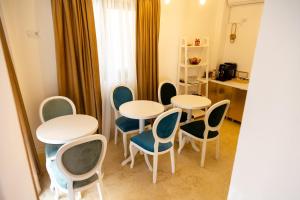 a group of tables and chairs in a room at Villa Jolie in Craiova