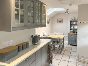 a kitchen with blue cabinets and a table with chairs at The Causeway in Eyam