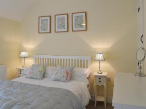 a bedroom with a bed with two lamps and two tables at The Causeway in Eyam
