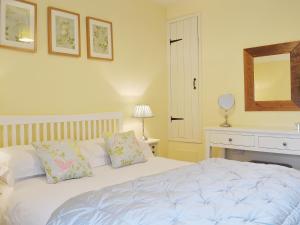 a bedroom with a white bed and a mirror at The Causeway in Eyam +4 photos