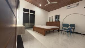 a room with a bed and two chairs in it at SeekRide Bolgoda in Bandaragama +3 photos