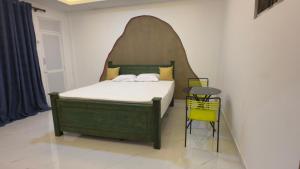 a bedroom with a bed with a headboard and a table at SeekRide Bolgoda in Bandaragama