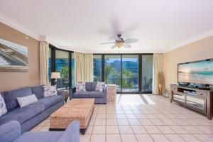 a living room with a couch and a flat screen tv at Phoenix on the Bay 1211 condo in Orange Beach