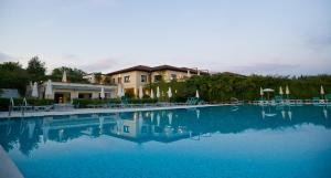 a large pool of blue water in front of a house at Asolo Golf Club in Cavaso del Tomba