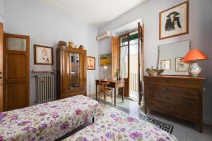ローマにあるColosseo Holiday Houseのベッドルーム1室(ベッド1台、ドレッサー、デスク付)