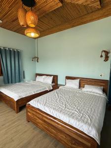 two twin beds in a room with at Homestay JB Sơn Hải in Thôn Sơn Hải