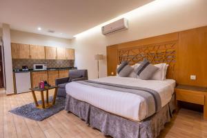 a hotel room with a large bed and a kitchen at Al Muhaidb Residence Al Malaz 4 - Economic in Riyadh