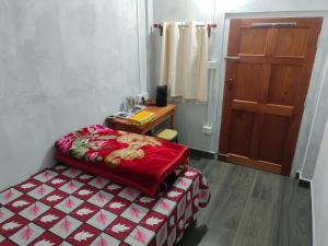 a room with a bed and a table and a door at Peter and Paul Homestay in Shillong +2 photos