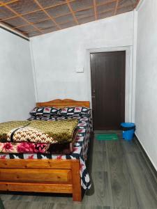 two beds in a room with a door at Peter and Paul Homestay in Shillong