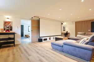 a living room with a couch and a projection screen at Le Ciné Lodge Provence in Flassans-sur-Issole