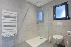 a bathroom with a shower with a toilet and a window at Le Ciné Lodge Provence in Flassans-sur-Issole +58 photos