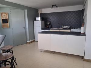 a white kitchen with a sink and a refrigerator at GITE LA NOTARIALE in Combles