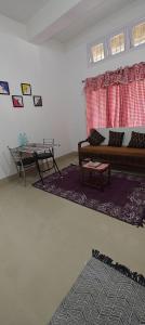 a living room with a couch and a table at La Paloma in Dispur +8 photos